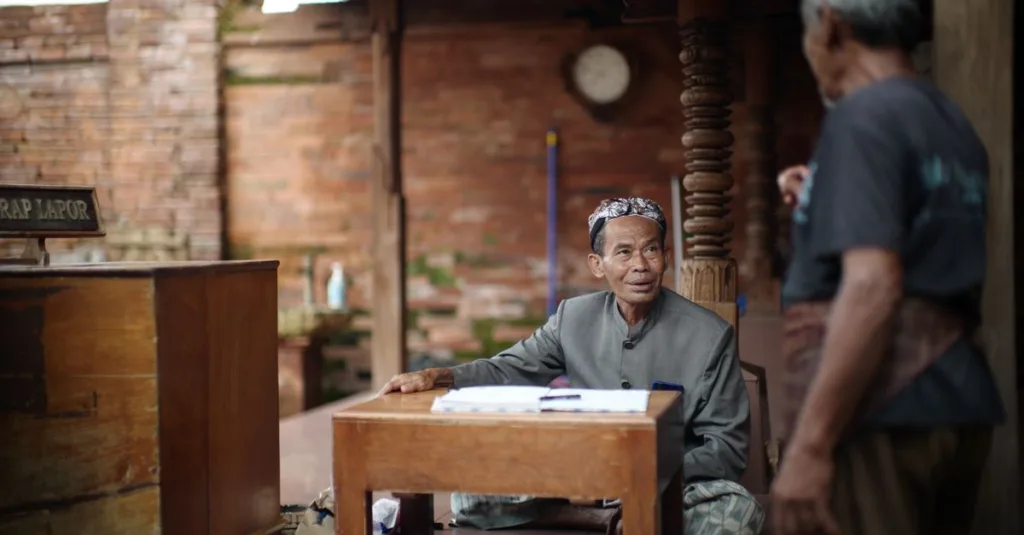 Dua pria terlibat dalam percakapan di lingkungan budaya di Kudus, Indonesia.