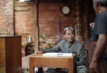 Dua pria terlibat dalam percakapan di lingkungan budaya di Kudus, Indonesia.