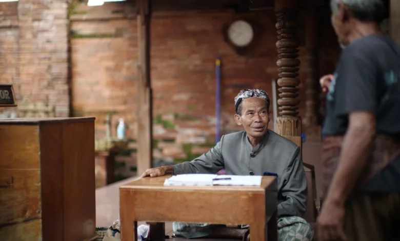 Dua pria terlibat dalam percakapan di lingkungan budaya di Kudus, Indonesia.