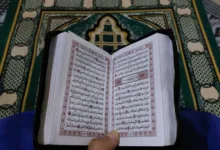 Orang yang membaca Al-Qur'an di karpet sholat tradisional di Tinghir, Maroko.
