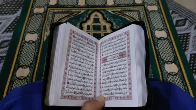 Orang yang membaca Al-Qur'an di karpet sholat tradisional di Tinghir, Maroko.