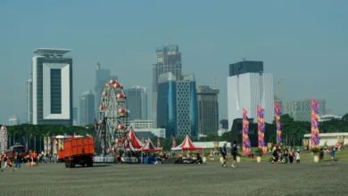 Karnaval kota dengan bianglala dan gedung pencakar langit di latar belakang, suasana perkotaan yang semarak.