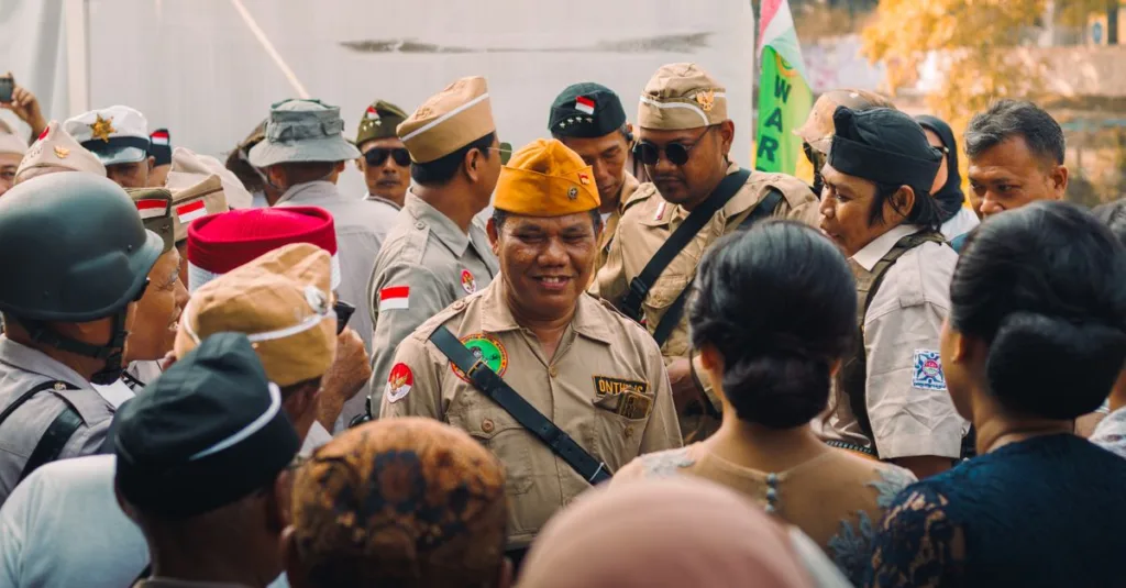 Sekelompok orang yang mengenakan seragam militer vintage dalam sebuah pertemuan di luar ruangan, kemungkinan untuk acara peringatan.