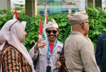Sekelompok veteran Indonesia berseragam menikmati percakapan di luar ruangan, menunjukkan rasa persahabatan.