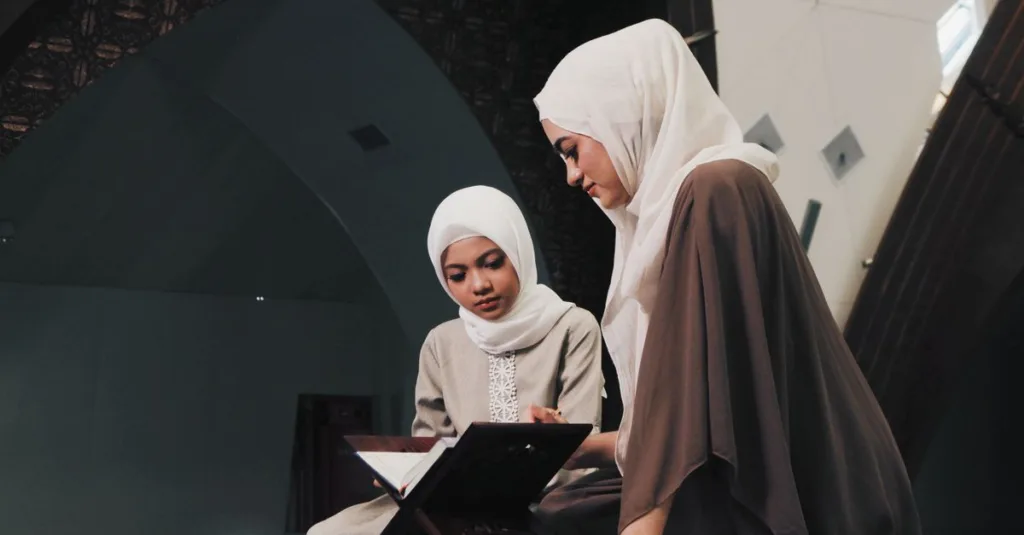 Dua wanita Muslim membaca Al-Qur'an di lingkungan masjid yang tenang di Bandung, Indonesia.