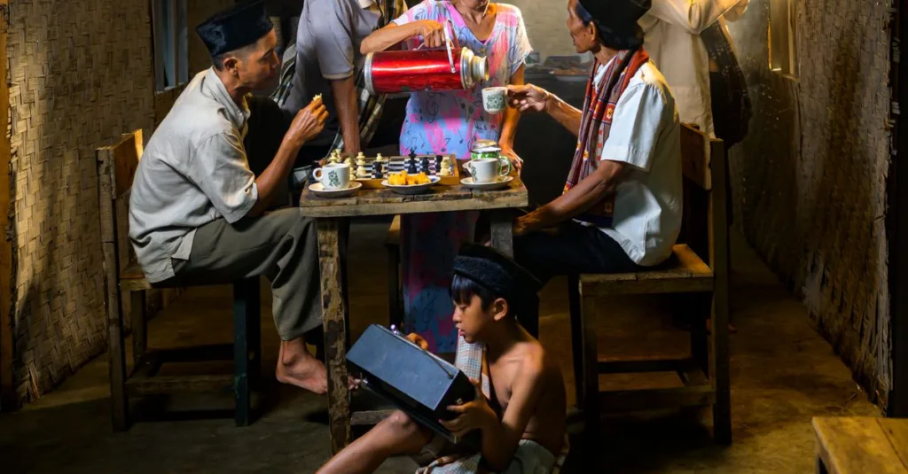 Sebuah keluarga Indonesia menikmati teh bersama dalam suasana tradisional yang nyaman.