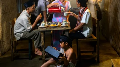 Sebuah keluarga Indonesia menikmati teh bersama dalam suasana tradisional yang nyaman.