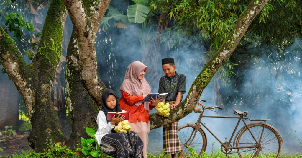 Anak-anak duduk di bawah pohon membaca buku di hari yang berkabut di Banten, Indonesia.
