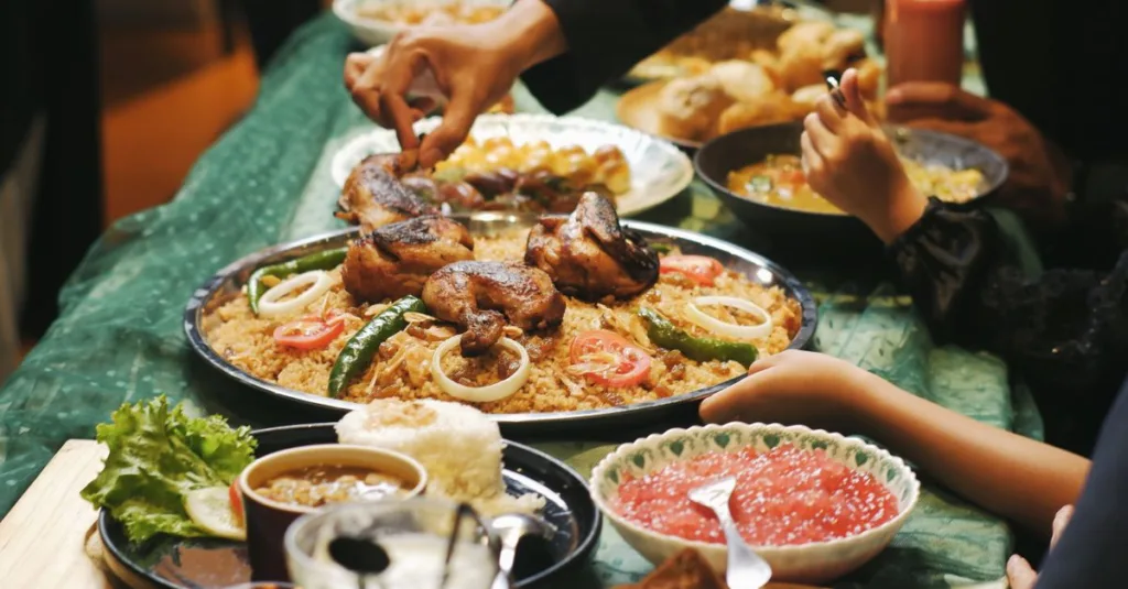 Orang-orang menikmati jamuan tradisional Ramadan di Indonesia dengan ayam, nasi, dan sambal.