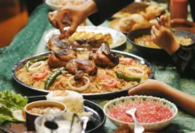 Orang-orang menikmati jamuan tradisional Ramadan di Indonesia dengan ayam, nasi, dan sambal.