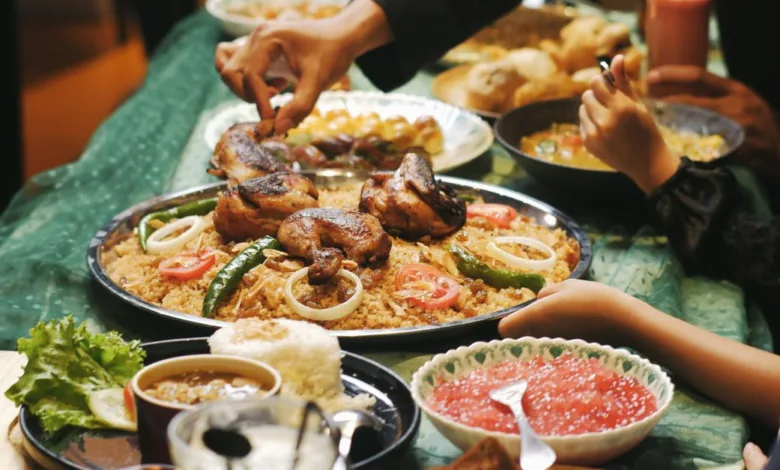 Orang-orang menikmati jamuan tradisional Ramadan di Indonesia dengan ayam, nasi, dan sambal.