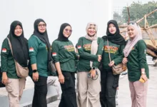 Enam wanita berpakaian hijau berkumpul untuk aktivitas pembentukan karakter di luar ruangan, menunjukkan kebersamaan dan persatuan.