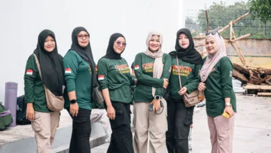 Enam wanita berpakaian hijau berkumpul untuk aktivitas pembentukan karakter di luar ruangan, menunjukkan kebersamaan dan persatuan.