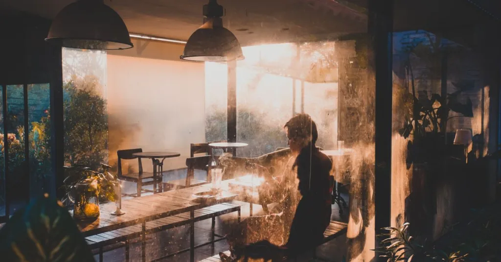 Sebuah momen tenang di kafe yang diterangi cahaya hangat matahari terbenam di Semarang, Indonesia.