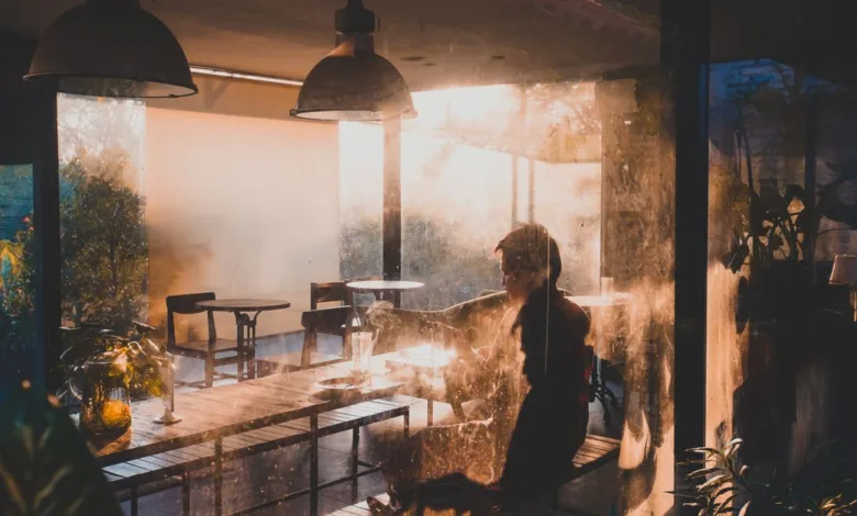 Sebuah momen tenang di kafe yang diterangi cahaya hangat matahari terbenam di Semarang, Indonesia.