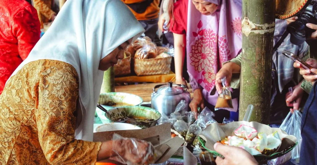 Pasar yang hidup dengan beragam orang terlibat dalam perdagangan lokal dan menikmati makanan jalanan.