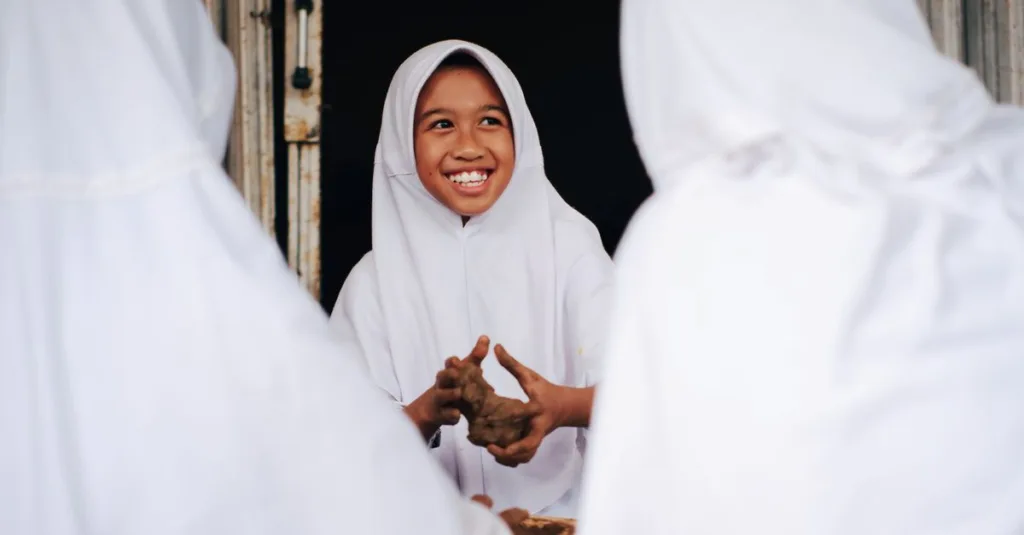 Siswa muda yang membuat kerajinan dari tanah liat mengenakan pakaian tradisional di sebuah sekolah di Jawa Barat, Indonesia.