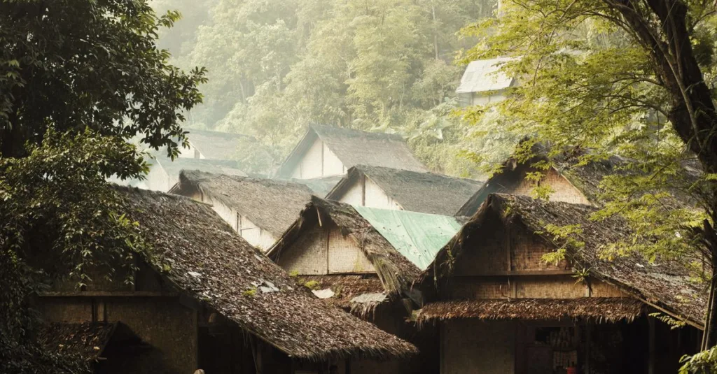 Rumah bambu rustik dikelilingi oleh pepohonan rimbun di Banten, Indonesia, menampilkan arsitektur tradisional.