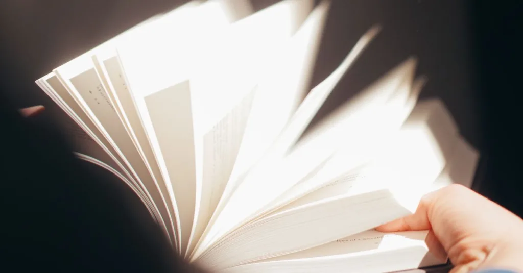 Gambar close-up yang detail menunjukkan pembalikan halaman buku secara dinamis dengan tangan.