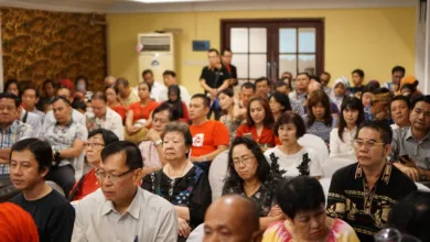 Sekelompok orang dewasa yang beragam menghadiri konferensi di sebuah pengaturan dalam ruangan di Indonesia.