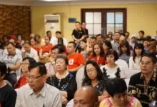 Sekelompok orang dewasa yang beragam menghadiri konferensi di sebuah pengaturan dalam ruangan di Indonesia.