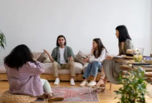 Sekelompok teman yang berbeda terlibat dalam percakapan di ruang tamu modern.